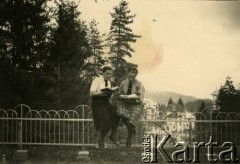 14.04.1940, Baile Govora, Rumunia.
Dwie młode kobiety siedzące na ogrodzeniu i czytajace książki, w tle fragment miasteczka; podpis na odwrocie: 