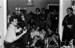Październik 1980, Warszawa, Polska.
Bankiet w mieszkaniu Elżbiety i Pawła Bąkowskich z okazji 100 publikacji Niezależnej Oficyny Wydawniczej NOWa, od lewej m.in.: Jacek Kaczmarski, Grzegorz Boguta, Julian Stryjkowski, Piotr Szwajcer, Ewa Milewicz, Joanna Walc, Wiktor Woroszylski, na podłodze siedzą: Hanna Bartoszewicz, Andrzej Mietkowski, Erazm Ciołek, Ewa Nawój, Stanisław Muskat.
Fot. Tomasz Abramowicz, zbiory Ośrodka KARTA
