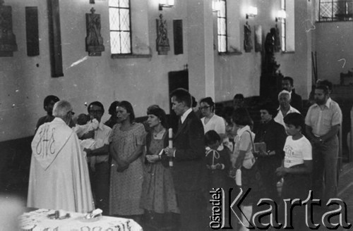 1977, Polska.
Chrzest dziecka Emila Morgiewicza, mszę odprawia ksiądz Jan Zieja, ojcem chrzestnym jest Andrzej Czuma (stoi ze świecą), z tyłu wśród gości m.in. Marzeną Kęcik, Marian Gołębiewski, Adam Wojciechowski.
Fot. Janusz Krzyżewski, zbiory Ośrodka KARTA

