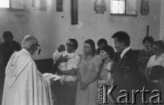 1977, Polska.
Chrzest dziecka Emila Morgiewicza (stoi z lewej), mszę odprawia ksiądz Jan Zieja, ojcem chrzestnym jest Andrzej Czuma (stoi ze świecą).
Fot. Janusz Krzyżewski, zbiory Ośrodka KARTA

