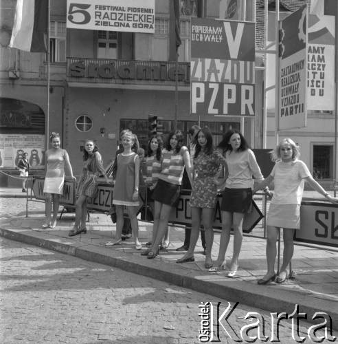 Czerwiec 1969, Zielona Góra, Polska.
Uczestnicy V Festiwalu Piosenki Radzieckiej na skrzyżowaniu Alei Niepodległości i ulicy Stefana Żeromskiego. W tle plakat reklamujący Festiwal i plakaty dotyczące V Zjazdu PZPR.
Fot. Romuald Broniarek, zbiory Ośrodka KARTA.