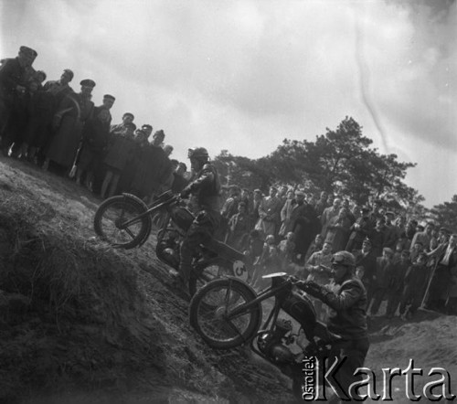 Marzec 1957, Zalesie Górne, Polska.
Zawody motocyklowe, publiczność obserwuje dwóch zawodników podjeżdżających pod górę.
Fot. Romuald Broniarek, zbiory Ośrodka KARTA