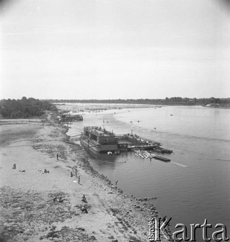 Lipiec 1957, Warszawa, Polska.
Warszawacy na plaży nad Wisłą, przy brzegu cumuje barka.
Fot. Romuald Broniarek, zbiory Ośrodka KARTA