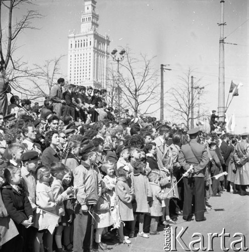 1.05.1958, Warszawa, Polska. 
Obchody święta 1 Maja, mieszkańcy stolicy oglądaja pochód pierwszomajowy. Na pierwszym planie grupa dzieci, w tle Pałac Kultury i Nauki.
Fot. Romuald Broniarek, zbiory Ośrodka KARTA