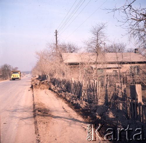 Marzec 1975, Dąbrowa Górnicza, woj. Katowice, Polska.
Budowa Huty Katowice, samochód ciężarowy na drodze prowadzącej do placu budowy, z prawej dom i zniszczony płot.
Fot. Romuald Broniarek/KARTA
