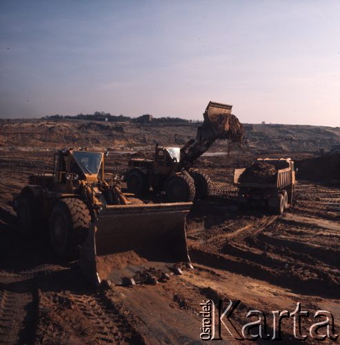 Marzec 1975, Dąbrowa Górnicza, woj. Katowice, Polska.
Budowa Huty Katowice, koparka ładująca ziemię na ciężarówkę.
Fot. Romuald Broniarek/KARTA
