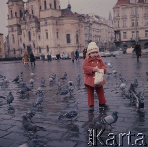 Luty 1976, Praga, Czechosłowacja
Rynek Starego Miasta (Staroměstské náměstí), w głębi po
lewej kościół św. Mikołaja, na pierwszym planie dziewczynka w czerwonym palcie karmiąca gołębie.
Fot. Romuald Broniarek/KARTA