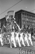 22.07.1956, Warszawa, Polska.
Uroczyste obchody Święta Odrodzenia Polski, defilada na ulicy Marszałkowskiej - młodzi mężczyźni w sportowych strojach niosą platformę z przedstawieniem biegacza na tle biało-czerwonej flagi.
Fot. Romuald Broniarek, zbiory Ośrodka KARTA