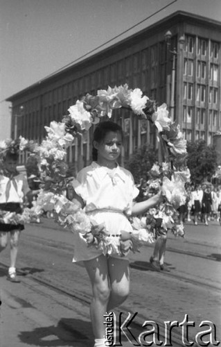 22.07.1956, Warszawa, Polska.
Uroczyste obchody Święta Odrodzenia Polski, defilada na ulicy Marszałkowskiej - dziewczynka z girlandą kwiatów.
Fot. Romuald Broniarek, zbiory Ośrodka KARTA