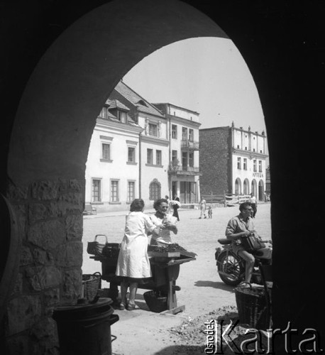 Lipiec 1956, Kazimierz Dolny, Polska.
Kazimierski Rynek, turystka kupuje owoce na straganie. 
Fot. Romuald Broniarek, zbiory Ośrodka KARTA