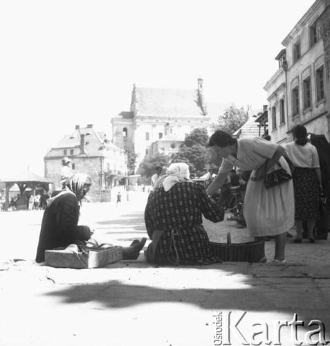 Lipiec 1956, Kazimierz Dolny, Polska.
Kazimierski Rynek, wiejskie kobiety sprzedające runo leśne. W tle zabytkowa studnia i kościół farny. 
Fot. Romuald Broniarek, zbiory Ośrodka KARTA