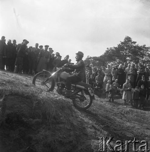 Marzec 1957, Zalesie Górne, Polska.
Zawody motocyklowe, publiczność obserwuje przejazd zawodnika z numerem 13.
Fot. Romuald Broniarek, zbiory Ośrodka KARTA