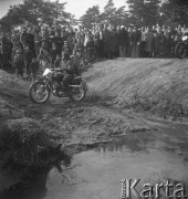 Marzec 1957, Zalesie Górne, Polska.
Zawody motocyklowe, publiczność obserwuje przejazd przez strumień zawodnika z numerem 10.
Fot. Romuald Broniarek, zbiory Ośrodka KARTA