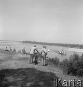 Lipiec 1957, Polska.
Ludzie nad brzegiem Wisły, na pierwszym planie para z motocyklem, w tle statek wycieczkowy.
Fot. Romuald Broniarek, zbiory Ośrodka KARTA