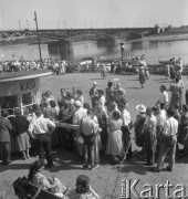 Lipiec 1957, Warszawa, Polska.
Warszawiacy na przystani nad Wisłą - kolejka do kasy dworca wodnego, w tle most średnicowy.
Fot. Romuald Broniarek, zbiory Ośrodka KARTA