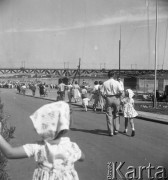 Lipiec 1957, Warszawa, Polska.
Warszawiacy na przystani nad Wisłą, na pierwszym planie dziewczynka w chustce na głowie, w tle most średnicowy.
Fot. Romuald Broniarek, zbiory Ośrodka KARTA