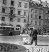 Sierpień 1957, Warszawa, Polska.
Krakowskie Przedmieście, na pierwszym planie starszy mężczyzna z dzieckiem w wózku, w tle trolejbus.
Fot. Romuald Broniarek, zbiory Ośrodka KARTA