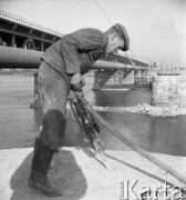 Wrzesień 1957, Warszawa, Polska.
Budowa Mostu Gdańskiego na filarach i z wykorzystaniem niektórych elementów konstrukcyjnych zburzonego Mostu przy Cytadeli. Robotnik ze świdrem.
Fot. Romuald Broniarek, zbiory Ośrodka KARTA