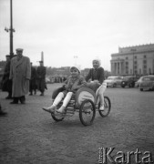 Październik 1957, Warszawa, Polska.
Dwoje dzieci w rikszy na Placu Defilad, w tle fragment Pałacu Kultury i Nauki.
Fot. Romuald Broniarek, zbiory Ośrodka KARTA