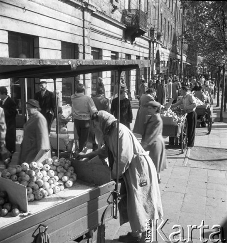 Październik 1957, Warszawa, Polska.
Stragany z owocami na warszawskiej ulicy, na pierwszym planie kobieta sprzedająca jabłka.
Fot. Romuald Broniarek, zbiory Ośrodka KARTA