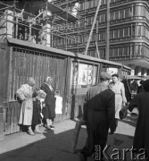 Październik 1957, Warszawa, Polska.
Aleje Jerozolimskie, dwie handlarki na ulicy, w tle Dom Handlowy Smyk. Na płocie wiszą plakaty reklamujące totolotka.
Fot. Romuald Broniarek, zbiory Ośrodka KARTA