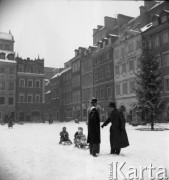 Styczeń 1958, Warszawa, Polska.
Rynek Starego Miasta - mężczyźni ciągną dzieci na sankach, z prawej stoi ośnieżona choinka.
Fot. Romuald Broniarek, zbiory Ośrodka KARTA