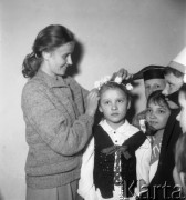 Styczeń 1958, Bielsk Podlaski, woj. Białystok, Polska.
Nauczycielka i dzieci w ludowych strojach podczas przygotowań do przedstawienia.
Fot. Romuald Broniarek, zbiory Ośrodka KARTA