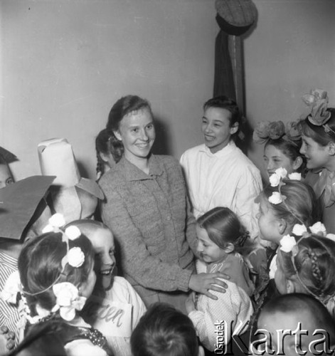 Styczeń 1958, Bielsk Podlaski, woj. Białystok, Polska.
Nauczycielka i dzieci w ludowych strojach podczas przygotowań do przedstawienia.
Fot. Romuald Broniarek, zbiory Ośrodka KARTA
