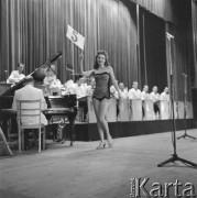 Kwiecień 1958, Warszawa, Polska.
Wybory Miss Katowic, będące eliminacjami konkursu Miss Polonia. Kandydatka z numerem 5 w kostiumie kąpielowym, w tle orkiestra.
Fot. Romuald Broniarek, zbiory Ośrodka KARTA