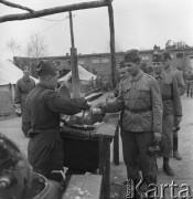 Maj 1958, Wesoła k/Warszawy, Polska.
Ćwiczenia żołnierzy 1 Warszawskiej Dywizji Zmechanizowanej, żołnierze z menażkami w kolejce do kuchni polowej.
Fot. Romuald Broniarek, zbiory Ośrodka KARTA