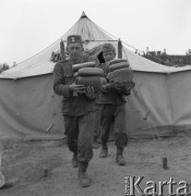 Maj 1958, Wesoła k/Warszawy, Polska.
Ćwiczenia żołnierzy 1 Warszawskiej Dywizji Zmechanizowanej, żołnierze z chlebem na tle namiotu.
Fot. Romuald Broniarek, zbiory Ośrodka KARTA
