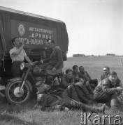 Maj 1958, Polska.
Radzieccy motocykliści, uczestnicy Motorowego Rajdu Przyjaźni - Moskwa-Warszawa-Moskwa, odpoczywają w cieniu ciężarówki.
Fot. Romuald Broniarek, zbiory Ośrodka KARTA