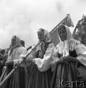 Czerwiec 1958, Łowicz, Polska.
Uroczystości Bożego Ciała - trzy kobiety w strojach ludowych, jedna z nich trzyma chorągiew.
Fot. Romuald Broniarek, zbiory Ośrodka KARTA