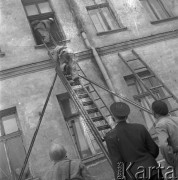 Czerwiec 1958, Warszawa, Polska.
Pożar w kamienicy, strażacy wchodzą po drabinie do mieszkania.
Fot. Romuald Broniarek, zbiory Ośrodka KARTA