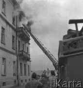 Czerwiec 1958, Warszawa, Polska.
Pożar w kamienicy - strażak wchodzi po drabinie do mieszkania, z którego okien bucha gęsty dym.
Fot. Romuald Broniarek, zbiory Ośrodka KARTA