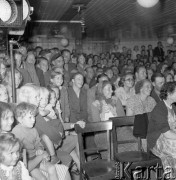 Lipiec 1958, Polska.
Teatr Ziemi Mazowieckiej podczas tournée na barce płynącej z biegiem Wisły - publiczność w czasie przedstawienia, z lewej siedzi grupa dzieci.
Fot. Romuald Broniarek, zbiory Ośrodka KARTA