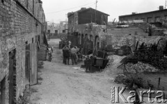 Wrzesień 1958, Warszawa, Polska.
Ulica Bagno, mężczyźni na podwórzu. W tle murarze wznoszący nowy dom.
Fot. Romuald Broniarek, zbiory Ośrodka KARTA