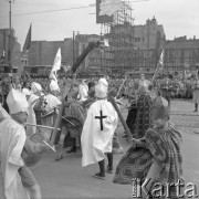 1.05.1959, Warszawa, Polska. 
Obchody święta 1 Maja, ulica Marszałkowska, na pierwszym planie inscenizacja walki z Krzyżakami w wykonaniu dzieci, w tle tłum obserwatorów i fragment hasła propagandowego: 