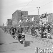 1.05.1959, Warszawa, Polska. 
Obchody święta 1 Maja, pochód uliczny, motocykliści jadą ulicą Marszałkowską. W oddali powiewają flagi PRL i ZSRR, po prawej stanowisko ekipy Telewizji Polskiej, w tle na budynku portrety Karola Marksa i Fryderyka Engelsa.
Fot. Romuald Broniarek, zbiory Ośrodka KARTA