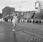 1.05.1959, Warszawa, Polska. 
Obchody święta 1 Maja, dziewczęta z obręczami podczas defilady na ulicy Marszałkowskiej, po prawej portret Włodzimierza Lenina, poniżej fragment hasła propagandowego: 