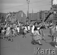 1.05.1959, Warszawa, Polska. 
Obchody święta 1 Maja, pochód na ulicy Marszałkowskiej, kobiety w strojach regionalnych. W tle po lewej powiewają flagi PRL i ZSRR dalej siedziba ekipy Telewizji Polskiej, po prawej u góry fragment portretu Włodzimierza Lenina.
Fot. Romuald Broniarek, zbiory Ośrodka KARTA