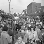 1.05.1959, Warszawa, Polska. 
Obchody święta 1 Maja, ulica Marszałkowska, uczestnicy pochodu niosą flagi PRL, w tle po prawej powiewają flagi PRL i ZSRR, na budynku wiszą portrety Karola Marksa i Fryderyka Engelsa.
Fot. Romuald Broniarek, zbiory Ośrodka KARTA