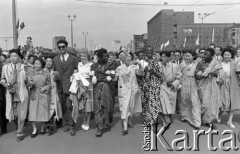 1.05.1959, Warszawa, Polska. 
Obchody święta 1 Maja, ulica Marszałkowska, obcokrajowcy idący w pochodzie, w oddali powiewają flagi PRL i ZSRR, na budynku wiszą portrety Karola Marksa i Fryderyka Engelsa.
Fot. Romuald Broniarek, zbiory Ośrodka KARTA