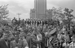 1.05.1959, Warszawa, Polska. 
Obchody święta 1 Maja, pochód przechodzący ulicą Marszałkowską obserwują milicjanci w mundurach i stojące powyżej pielęgniarki, w tle fragment Pałacu Kultury i Nauki.  
Fot. Romuald Broniarek, zbiory Ośrodka KARTA