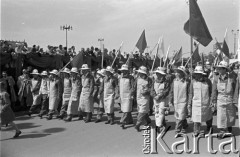 1.05.1959, Warszawa, Polska. 
Obchody święta 1 Maja, pochód przechodzący ulicą Marszałkowską. Robotnicy niosą flagi Polski i ZSRR, po lewej fragment trybuny honorowej, na niej w oddali w jasnym kapeluszu stoi prezydent Indonezji Ahmed Sukarno, na lewo od niego I sekretarz KC PZPR Władysław Gomułka, po prawo przewodniczący Rady Państwa Aleksander Zawadzki.
Fot. Romuald Broniarek, zbiory Ośrodka KARTA