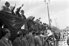 1.05.1959, Warszawa, Polska. 
Obchody święta 1 Maja, ulica Marszałkowska, I sekretarz KC PZPR Władysław Gomułka stojący na trybunie honorowej odbiera kwiaty  od uczestników pochodu, obok niego w kapeluszu stoi premier Józef Cyrankiewicz.
Fot. Romuald Broniarek, zbiory Ośrodka KARTA