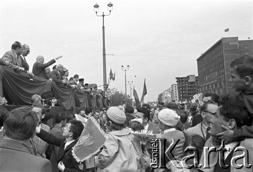 1.05.1959, Warszawa, Polska. 
Obchody święta 1 Maja, tłum zwrócony w kierunku trybuny honorowej, na niej trzeci od lewej stoi premier Józef Cyrankiewicz, piąty I sekretarz KC PZPR Władysław Gomułka, za nim kolejno prezydent Indonezji Ahmed Sukarno i przewodniczący Rady Państwa Aleksander Zawadzki, po prawej budynki przy ulicy Marszałkowskiej.
Fot. Romuald Broniarek, zbiory Ośrodka KARTA