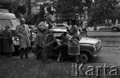 3-17.05.1959, Warszawa, Polska. 
XII kiermasz książki, mężczyźni i kobiety przy samochodach, kobieta po lewej trzyma 18 numer włoskiego czasopisma 