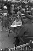 3-17.05.1959, Warszawa, Polska.
XII kiermasz książki, czytelnicy siedzący na krzesłach pod parasolami, wśród nich małe dziwczynki, jedna przegląda książkę.
Fot. Romuald Broniarek, zbiory Ośrodka KARTA