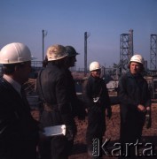 Marzec 1975, Dąbrowa Górnicza, woj. Katowice, Polska.
Budowa Huty Katowice, grupa robotników w kaskach i kombinezonach roboczych na placu budowy.
Fot. Romuald Broniarek, zbiory Ośrodka KARTA